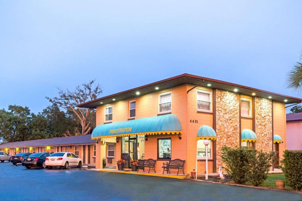 a hotel with cars parked in a parking lot at Knights Inn Kissimmee in Kissimmee