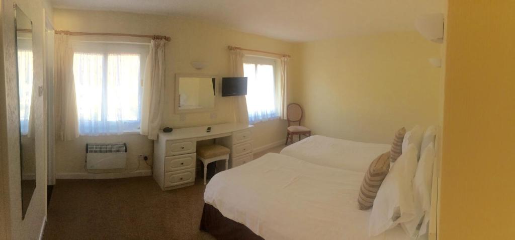 una camera con letto, cassettiera e specchio di Beau Rivage a St Brelade