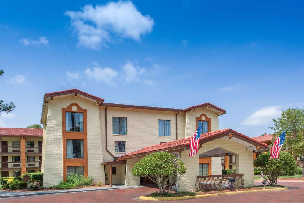 a hotel with two american flags in front of it at Knights Inn - Lithonia in Lithonia