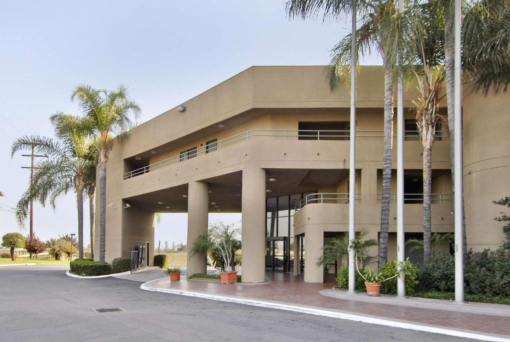 a building with palm trees in front of it at Travelodge by Wyndham Commerce Los Angeles Area in Commerce