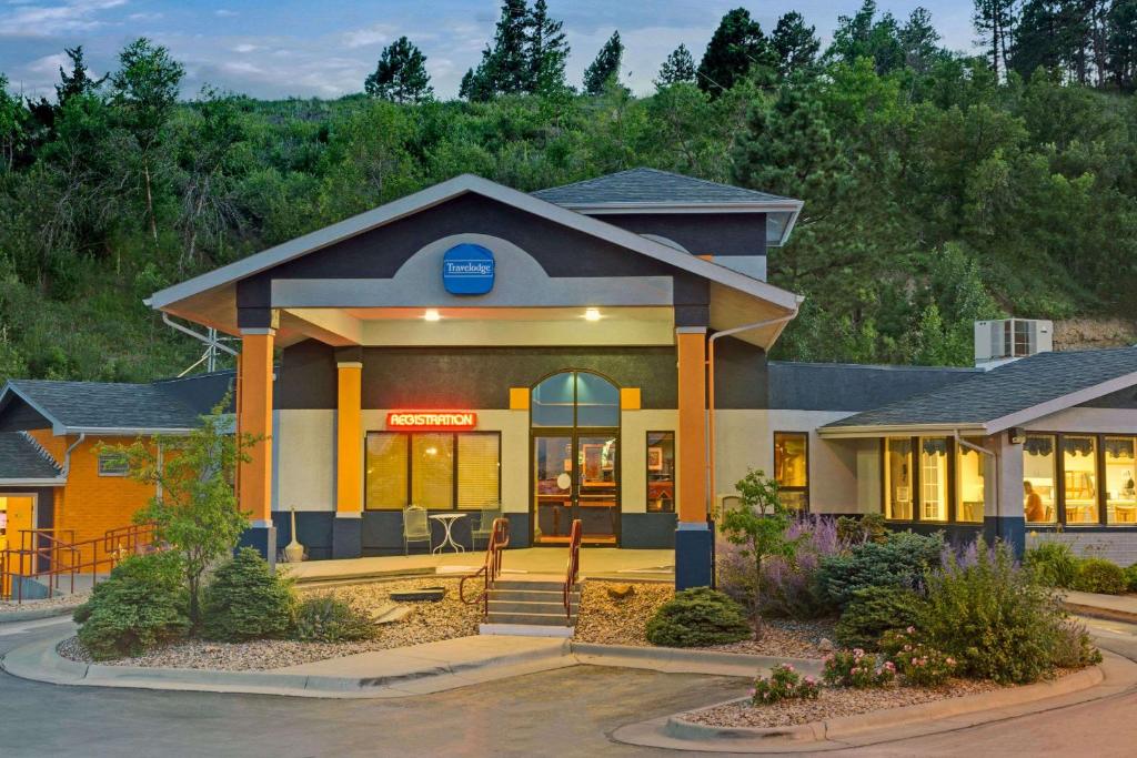 a building with a sign in front of it at Travelodge by Wyndham Rapid City in Rapid City