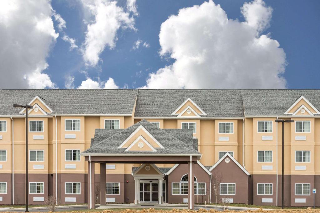 a large tan building with a gray roof at Microtel Inn & Suites by Wyndham Beaver Falls in Beaver Falls