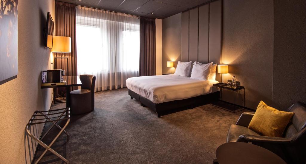 Design Hotel Glow في أيندهوفن: غرفه فندقيه بسرير ونافذه