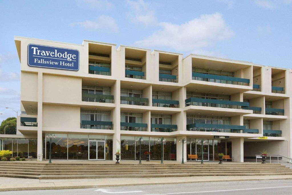 a large white building with a sign on it at Travelodge by Wyndham Niagara Falls Fallsview in Niagara Falls