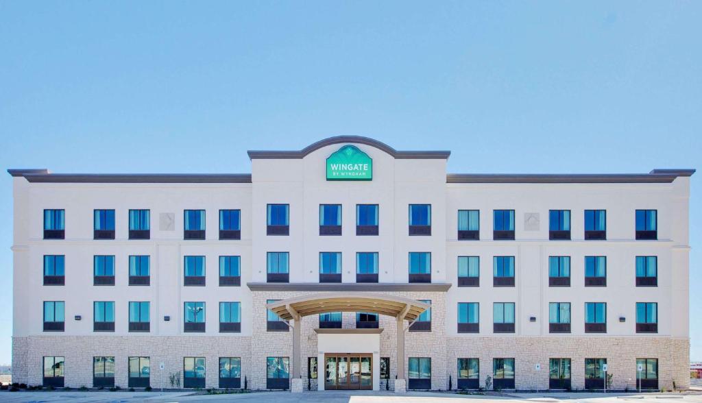 an office building with a sign on top of it at Wingate by Wyndham San Angelo in San Angelo