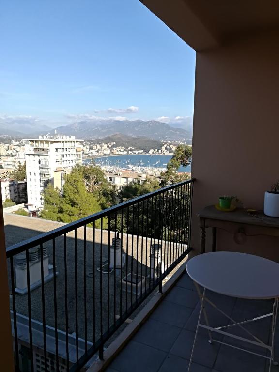 un balcon avec une table et une vue sur une ville dans l'établissement Appartement Lumineux Vue Panoramique, à Ajaccio