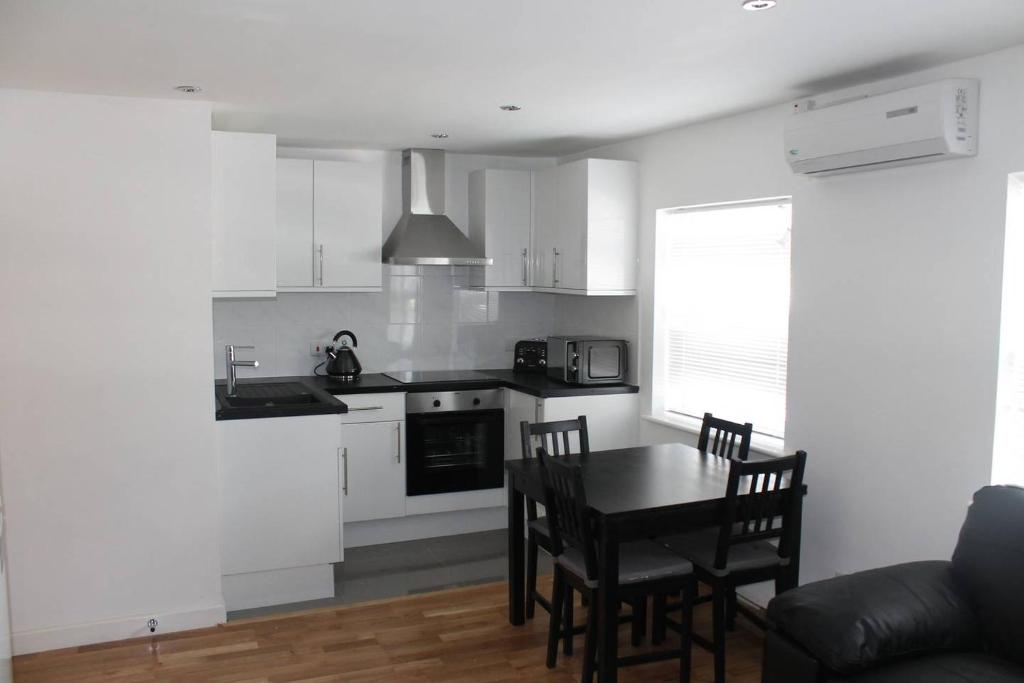 a kitchen with a table and chairs in a room at Modern Apartment in Trendy Dalston in London