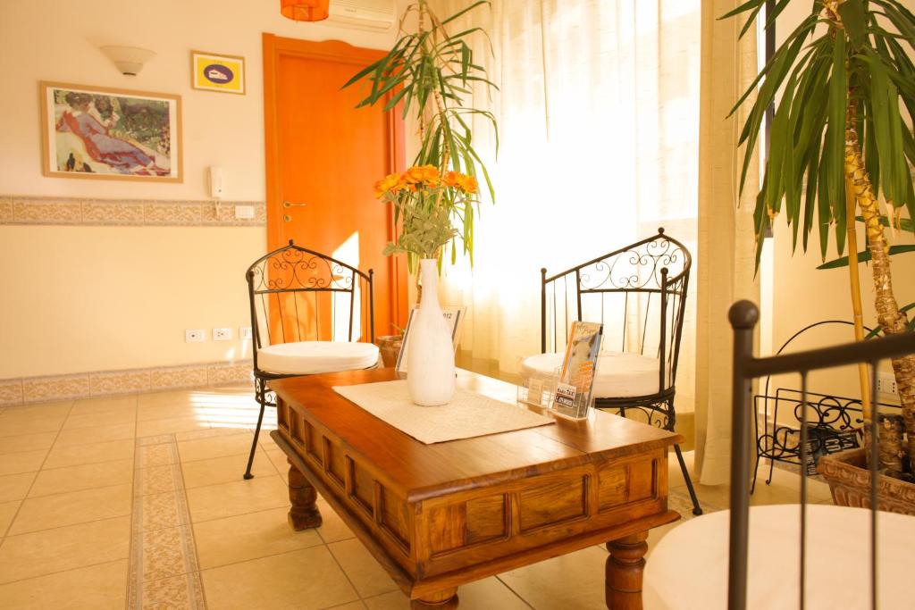 uma sala de estar com uma mesa e duas cadeiras em Marisal Accommodation em Alghero