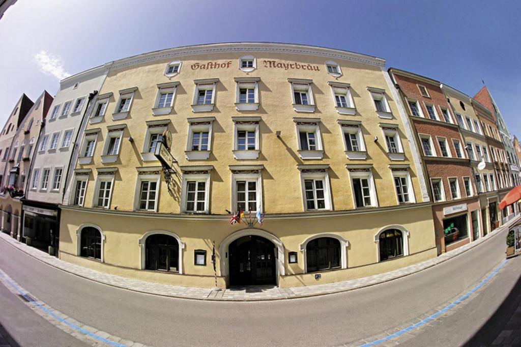 ein großes gelbes Gebäude vor einer Straße in der Unterkunft Hotel Mayrbräu in Braunau am Inn