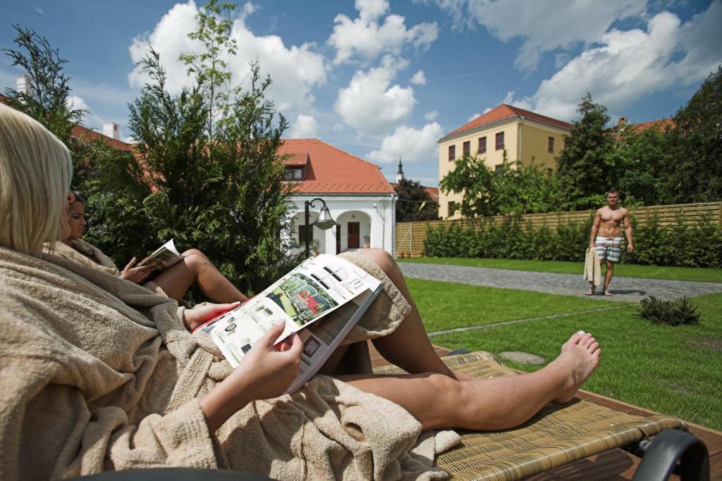 a man laying on a bench next to a woman at Hotel Historia & Historante in Veszprém