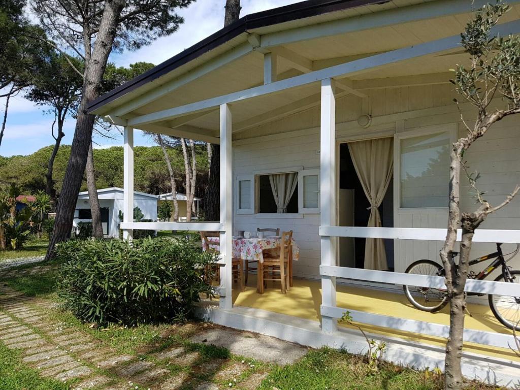 a small white house with a porch and a table at Villaggio Campeggio Nettuno di Paestum in Paestum