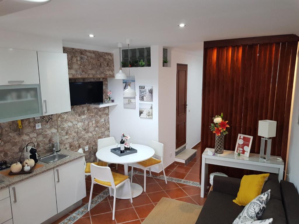 a kitchen and a living room with a table at Apartamento Sado II in Setúbal
