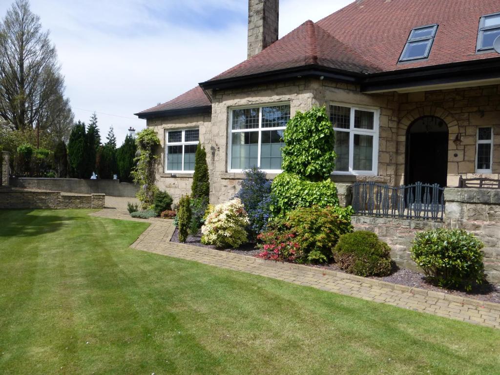 una casa con césped delante en The Cairn Residence, en Edimburgo