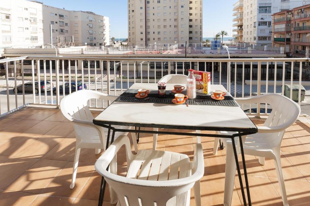 a table and chairs on a balcony with a view of a city at Niza in Gandía