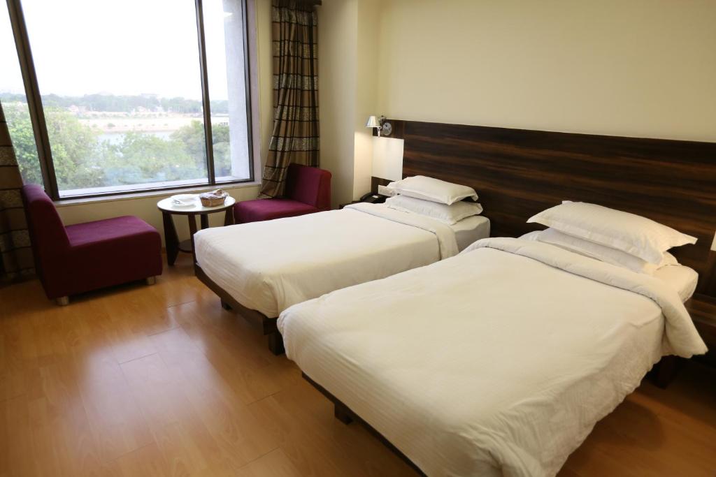 Postel nebo postele na pokoji v ubytování SilverCloud Hotel and Banquets