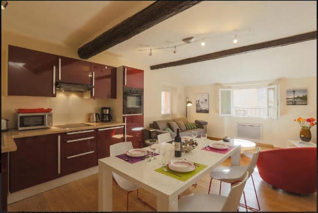 a kitchen and living room with a white table and chairs at Nice Renting - COLONNA - Best place in Nice Old Town in Nice