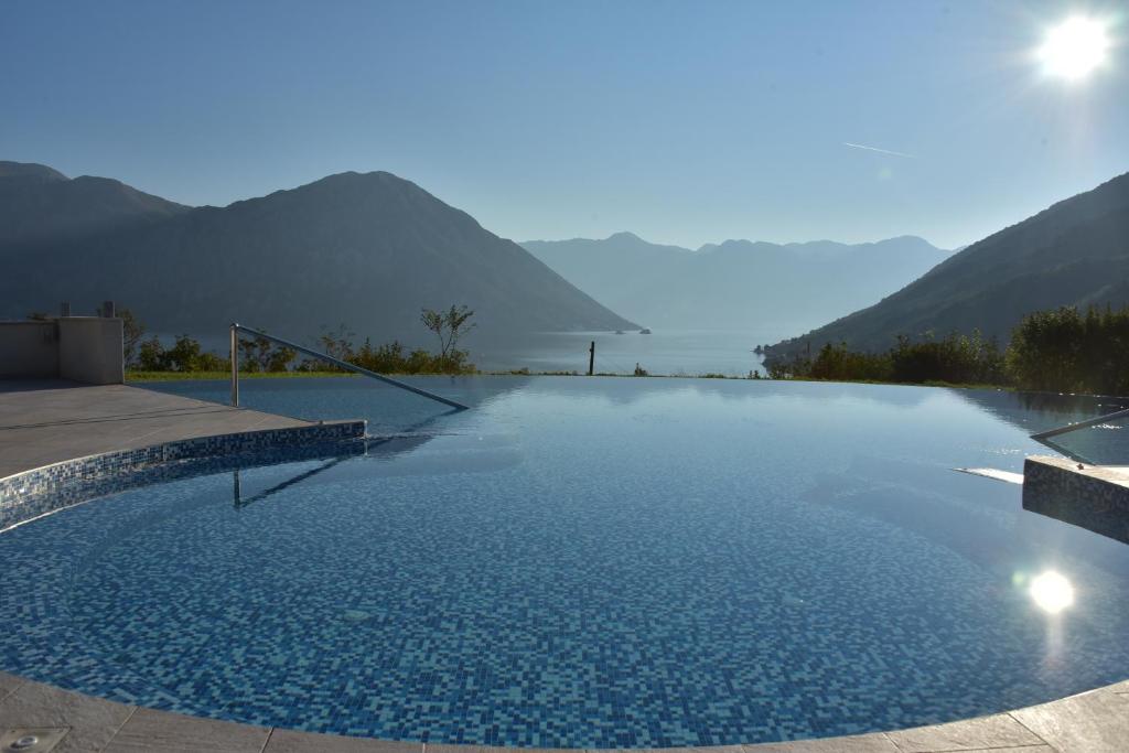 a swimming pool with a view of the mountains at Lavender Bay Apartment in Donji Morinj