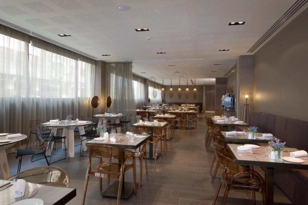 a dining room with tables and chairs in a restaurant at PCM Forum Alcalá in Alcalá de Henares