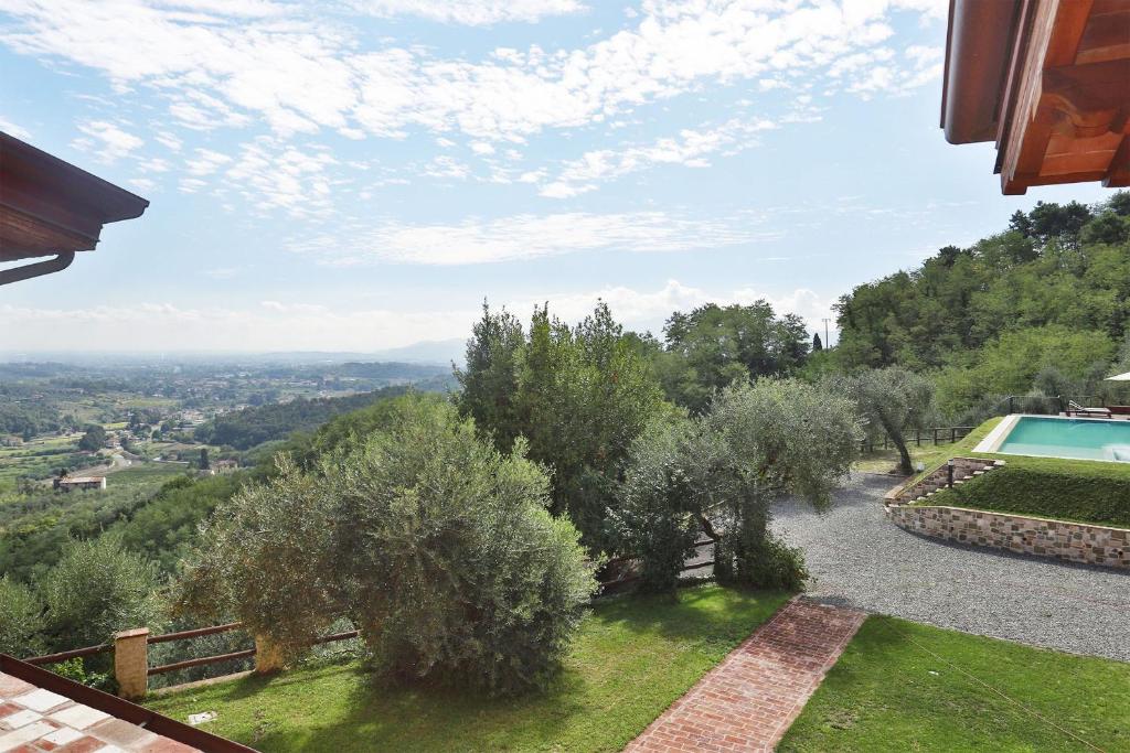 uma vista para um quintal com árvores e uma piscina em Santo Stefano 10 em Lucca