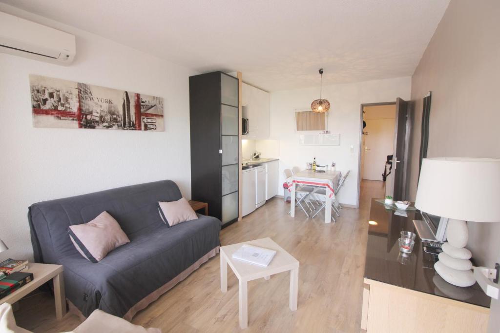 ein Wohnzimmer mit einem Sofa und einem Tisch in der Unterkunft Studio Olympe in Juan-les-Pins
