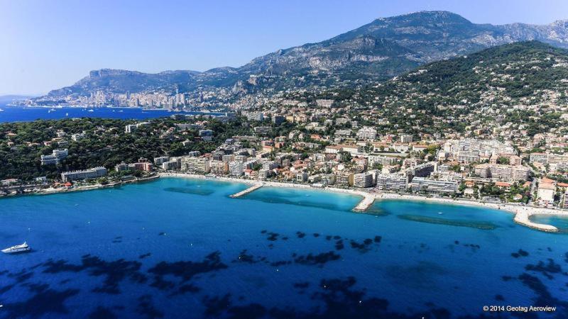 eine Luftansicht auf eine Stadt und das Meer in der Unterkunft STUDIO or ONE BEDROOM Avenue de la plage in Roquebrune-Cap-Martin