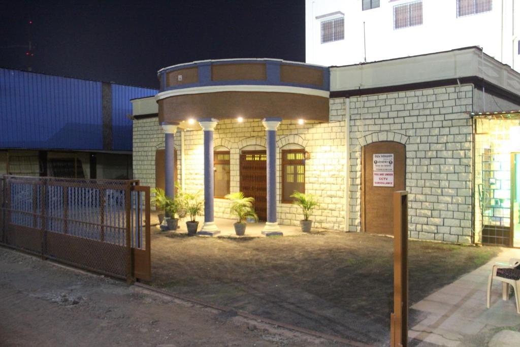 een gebouw met een hek er 's nachts voor bij Yuvraj Lodge in Osmānābād