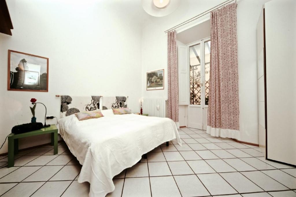 um quarto branco com uma cama e uma janela em Faenza Novella em Florença