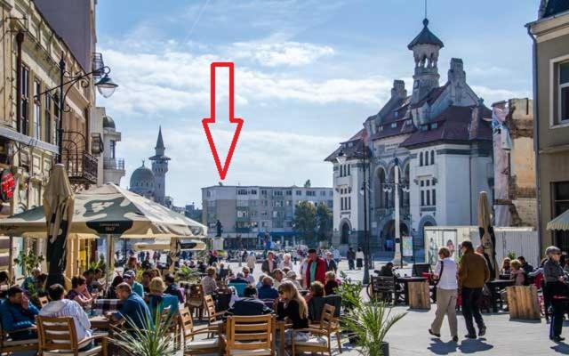 a red arrow is pointing down a city street at Piata Ovidiu Square in Constanţa