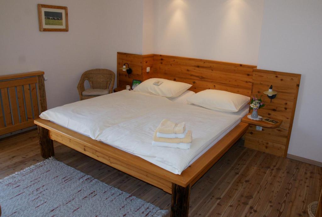 a bedroom with a large bed with a wooden headboard at Almenlandhof in Fladnitz an der Teichalm