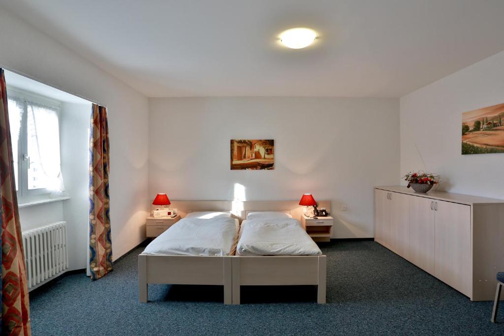una camera da letto con un letto e due comodini di Hôtel du Port - Free Parking - Breakfast included a Estavayer-le-Lac