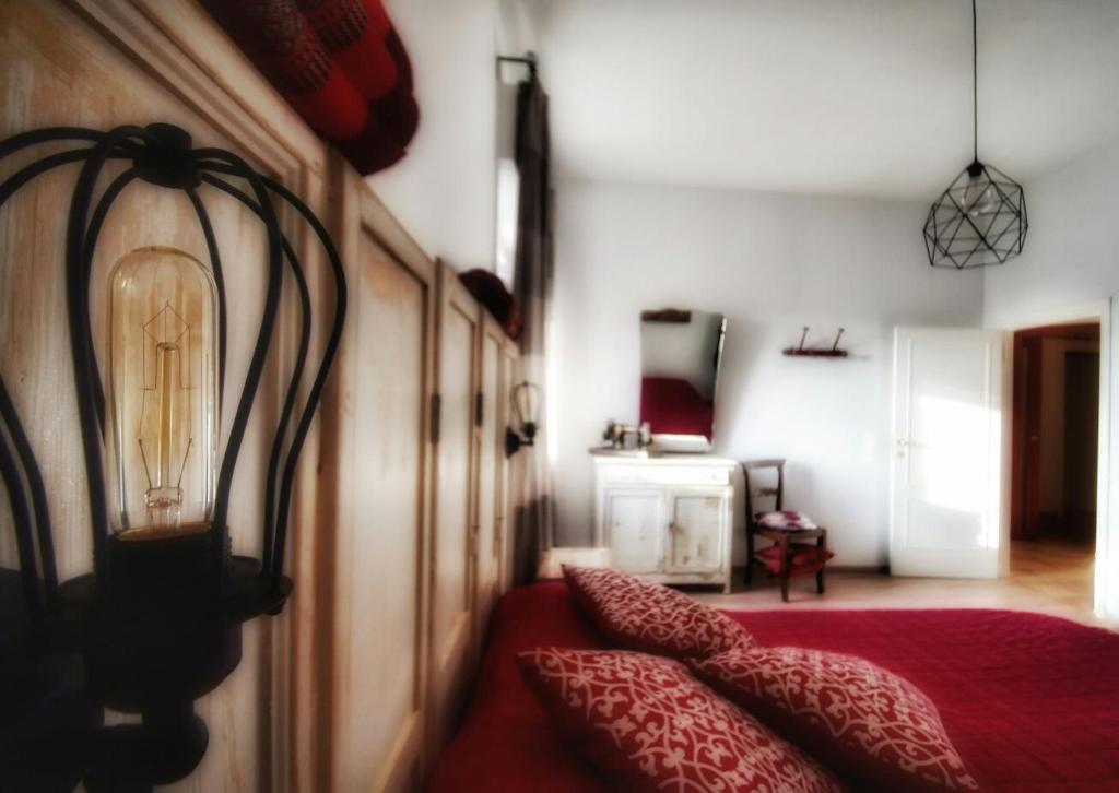 Un dormitorio con una cama roja con una lámpara. en B&B Teranga, en Montecarotto