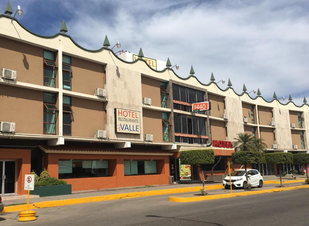 un bâtiment d'hôtel avec une voiture garée devant lui dans l'établissement Hotel del Valle, à Culiacán