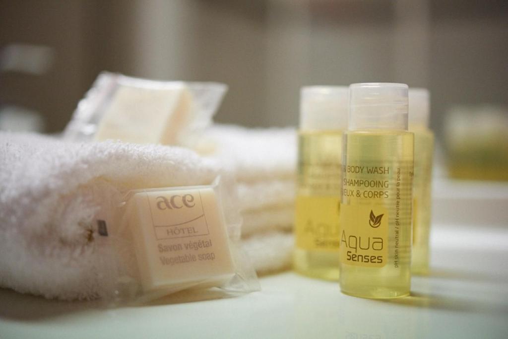 a close up of two bottles of soap and towels at Ace Hôtel Salon de Provence in Salon-de-Provence