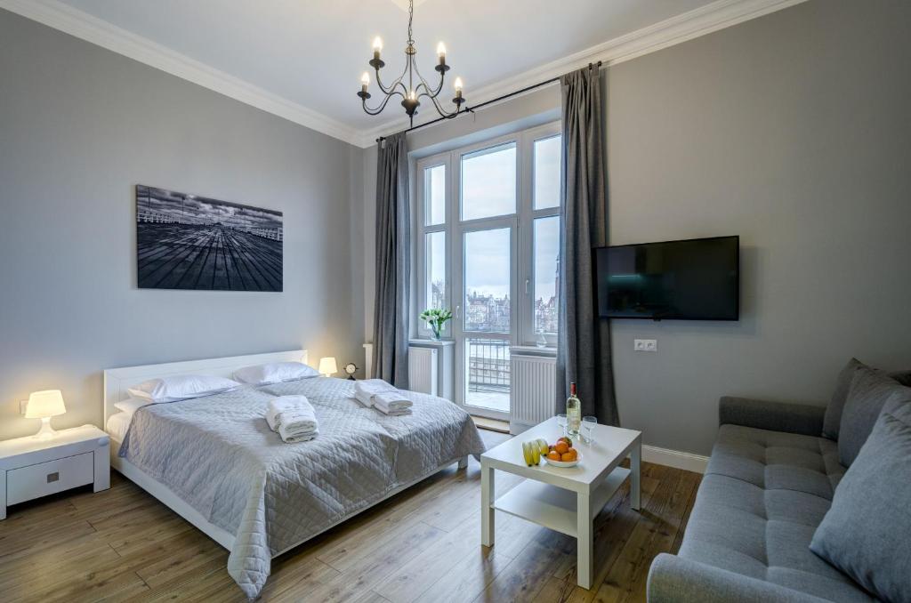 ソポトにあるDom & House - Apartments Podjazd Central Sopotのベッドルーム(ベッド1台、ソファ付)