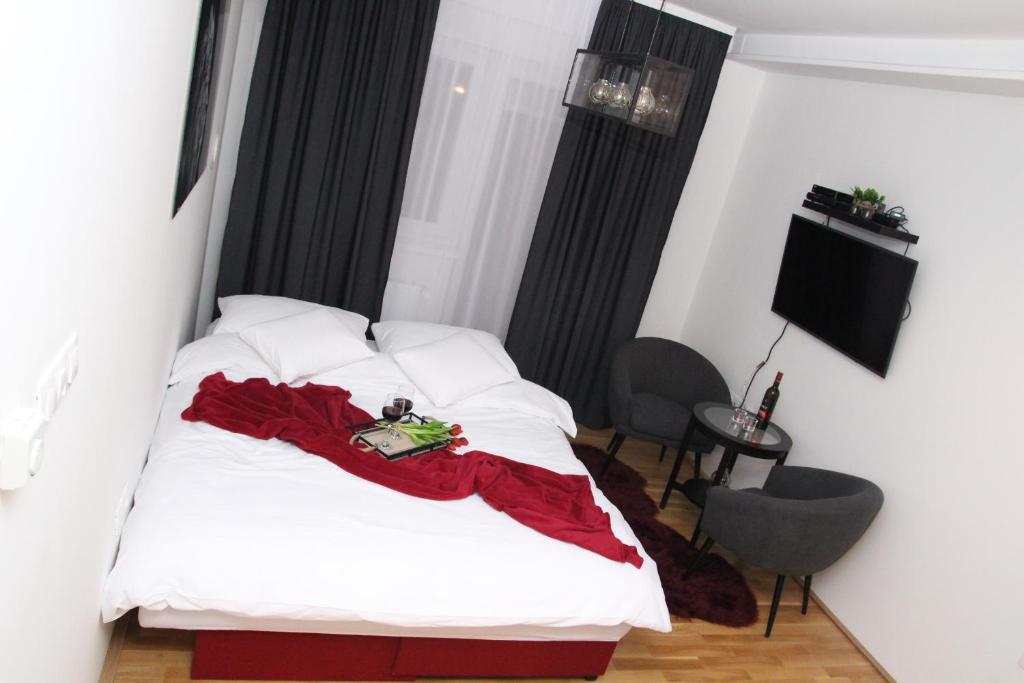 Un dormitorio con una cama con una manta roja. en Top Center, en Osijek