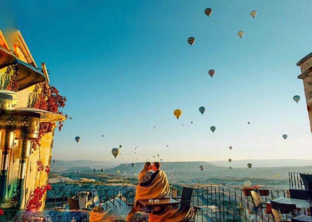 a group of hot air balloons flying in the sky at La Casa Cave Hotel in Uçhisar