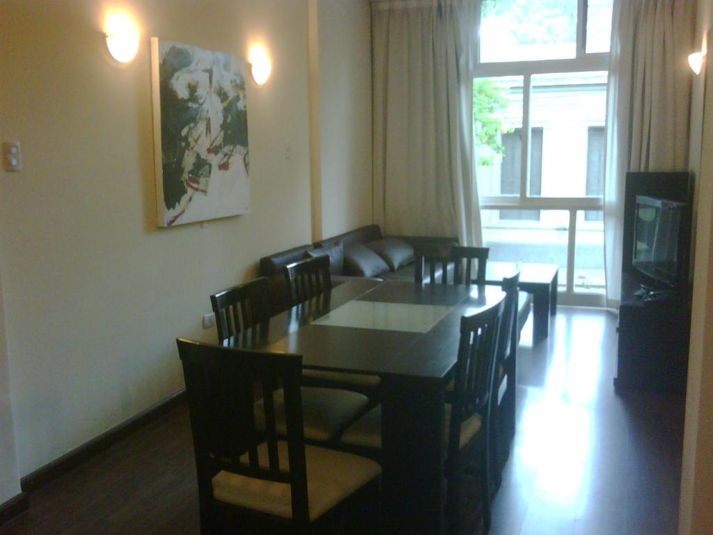 comedor con mesa, sillas y sofá en Apartamentos Centricos en Mendoza