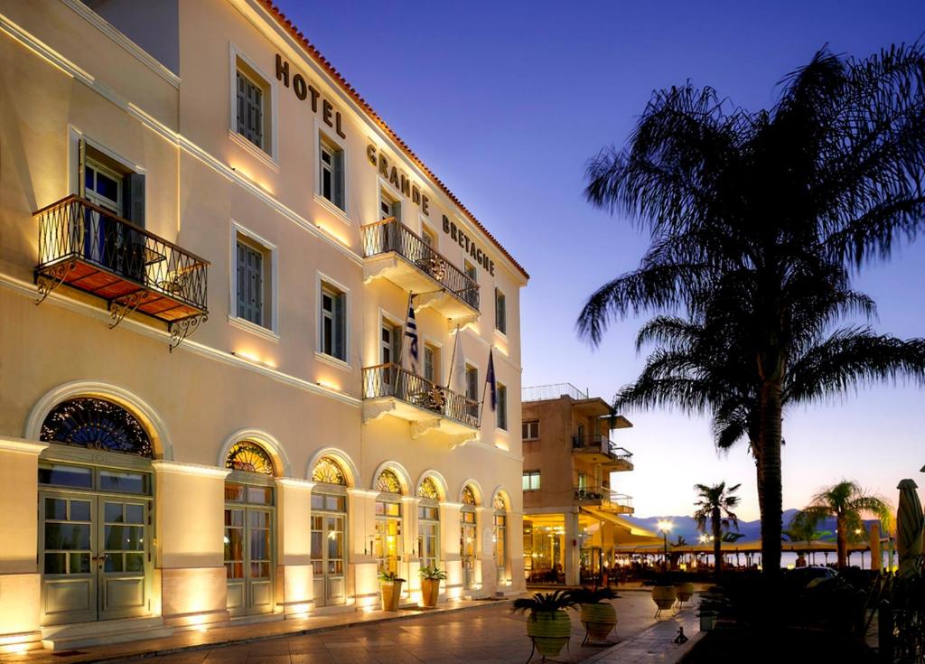 a large white building with a palm tree in front of it at Grande Bretagne - Nafplio in Nafplio