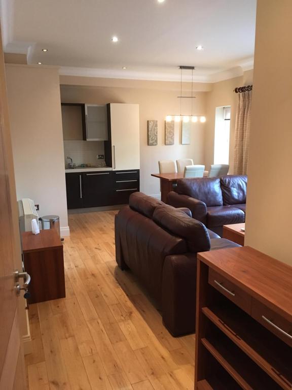 a living room with a couch and a kitchen at Beautiful Killarney Apartment in Killarney