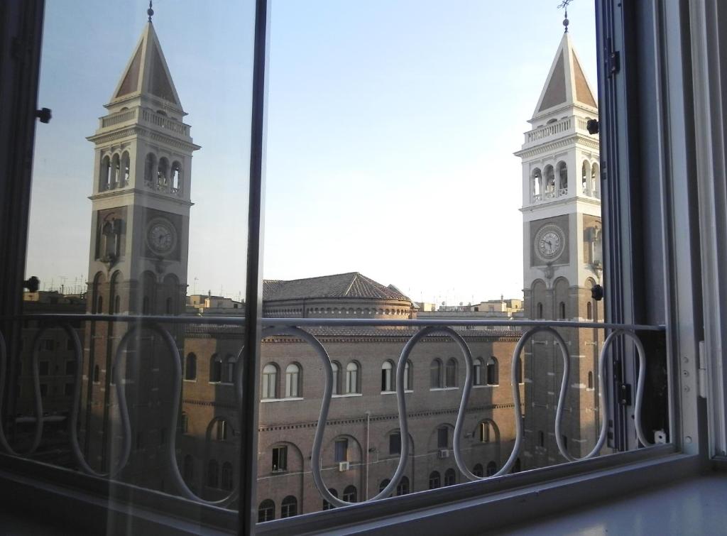 uma vista para um edifício com uma torre de relógio a partir de uma janela em LINE-UP Apartment em Roma
