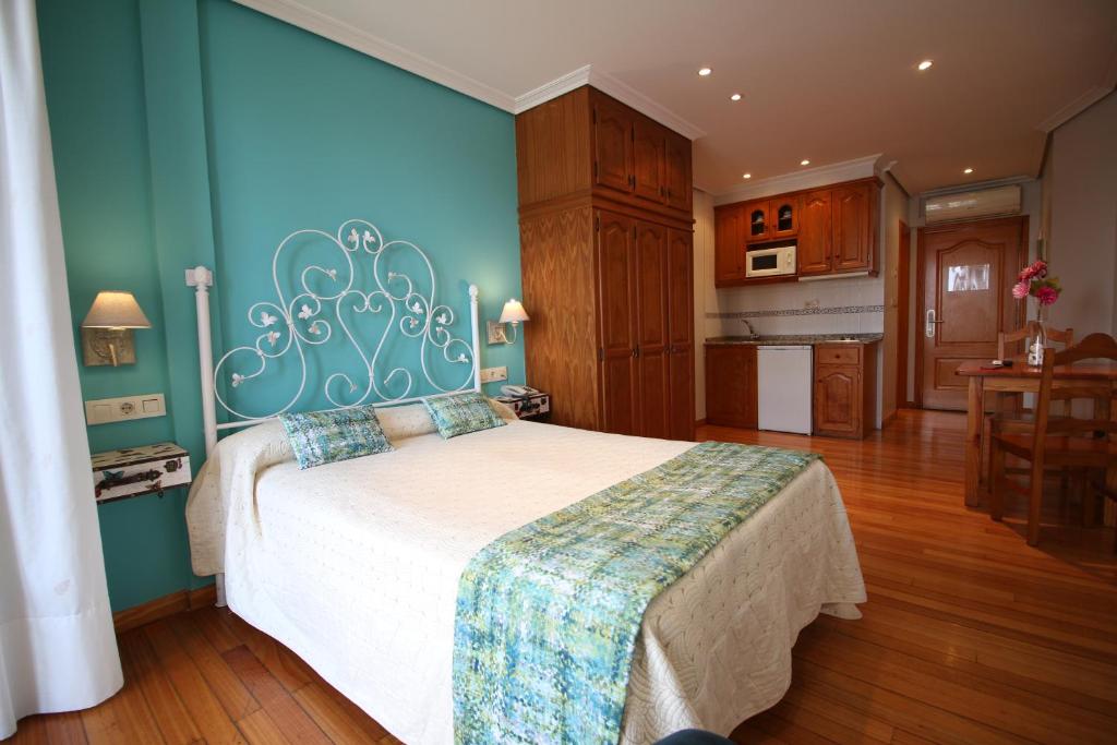 ein Schlafzimmer mit einem großen Bett mit blauer Wand in der Unterkunft Apartamentos Alda Porta do Sol in Vigo