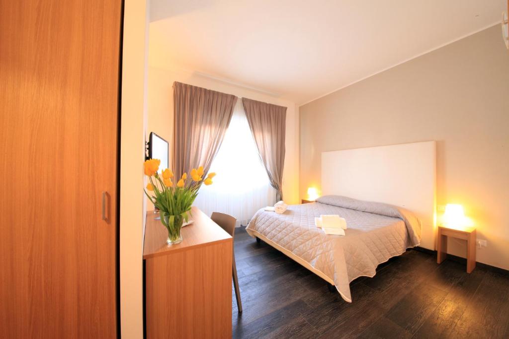 a bedroom with a bed and a vase of flowers on a table at B&B Al Picchio in Monopoli
