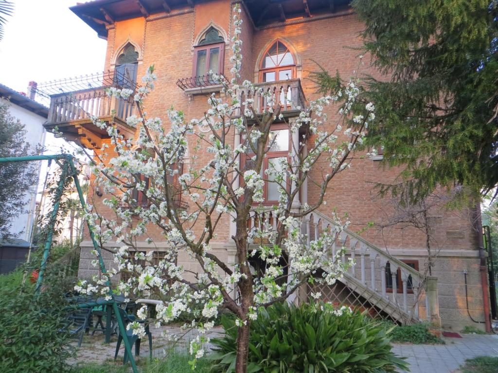 uma árvore com flores brancas em frente a um edifício em Villa Elisabetta em Veneza-Lido