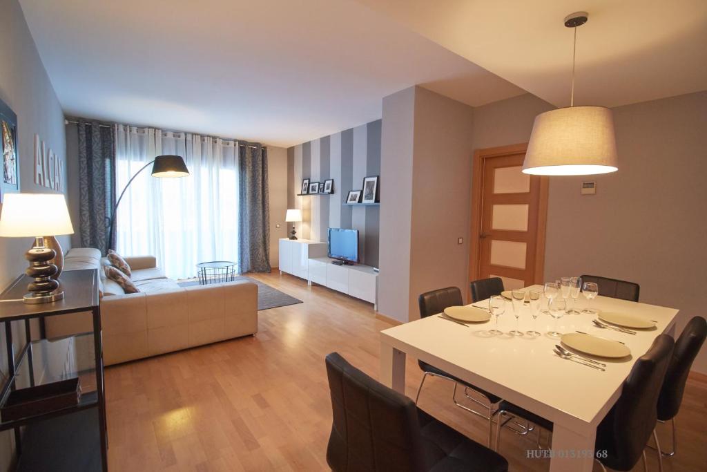 a dining room and living room with a table and chairs at Alcam Badalona Playa Norte in Badalona