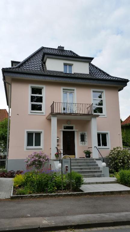 Cette maison blanche dispose d'un balcon et d'un escalier. dans l'établissement Tal-Residenz Erdgeschoss, à Bad Salzuflen