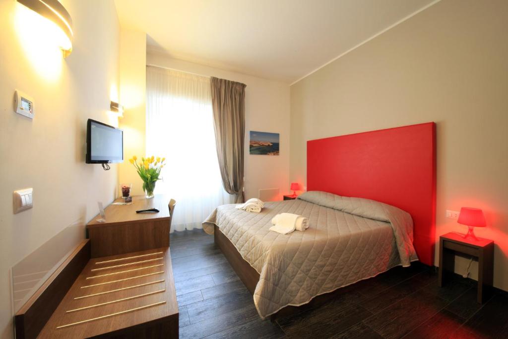 a hotel room with a bed with a red headboard at B&B Al Picchio in Monopoli