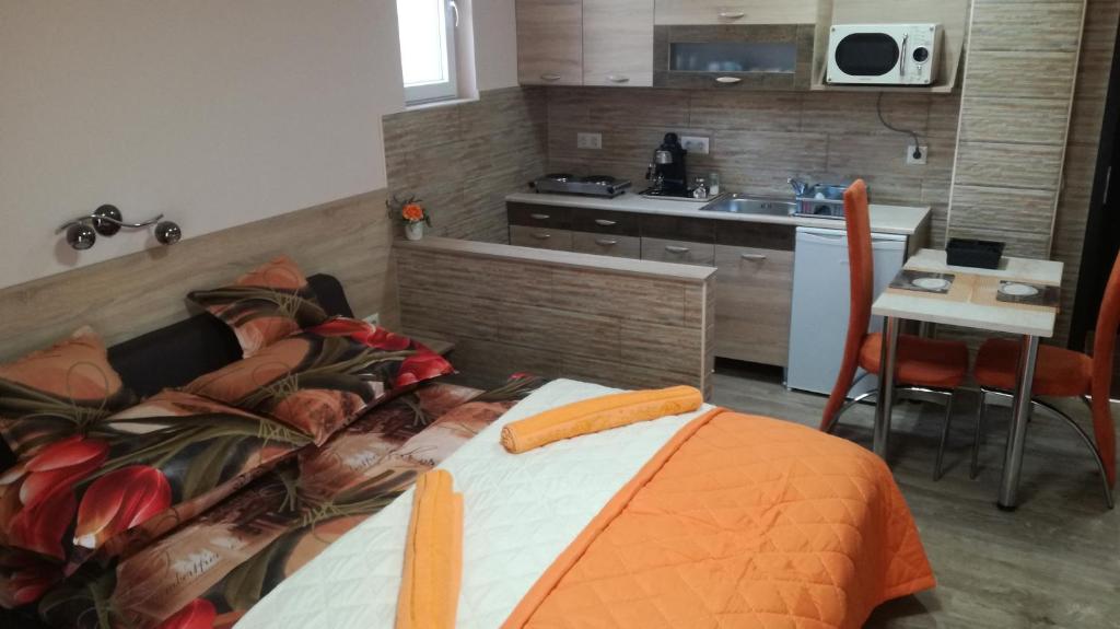 1 dormitorio con 1 cama y cocina con fregadero en Kéri Vendégház, en Mosonmagyaróvár