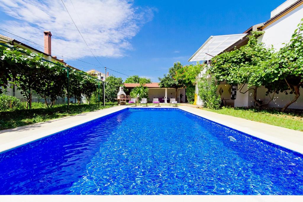 niebieski basen przed domem w obiekcie Villa Toni w mieście Umag
