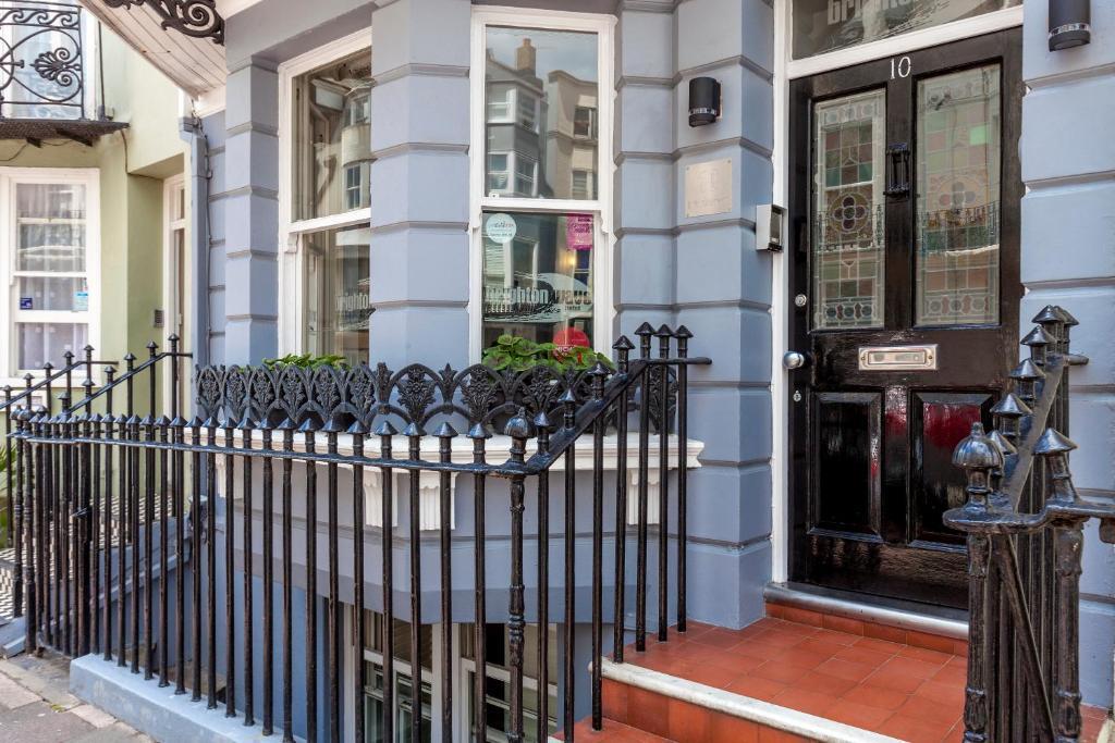 a black front door of a house with a fence at Brightonwave in Brighton & Hove