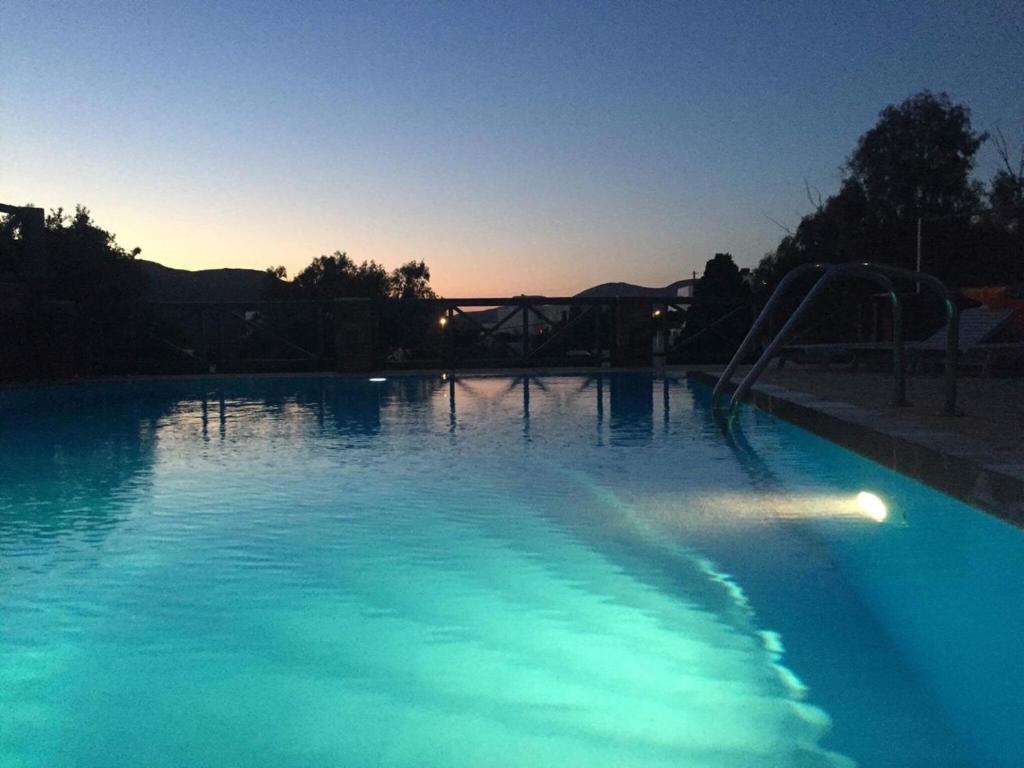 a swimming pool at night with a slide in it at Nefeli rooms Ios in Ios Chora
